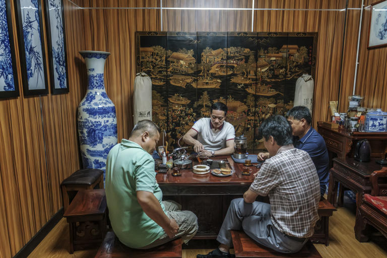 Chinese business executives drink tea at the Seaside Tobacco Company, on the island of Mahe.