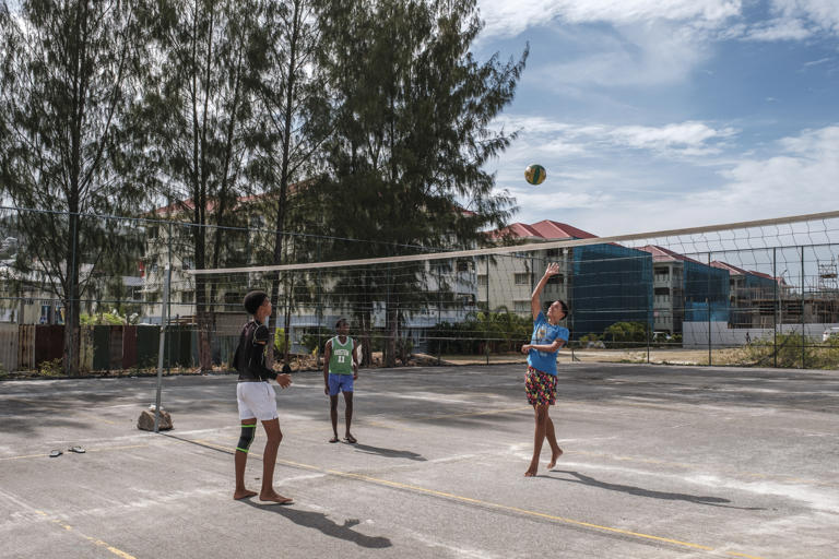 Teenagers play volleyball behind subsidized-housing buildings, built by the Chinese government, on the island of Mahe.