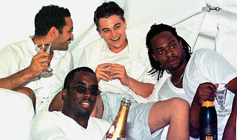 Leonardo DiCaprio enjoying some laughs with Diddy and his crew at one of the earliest White Parties in the Hamptons. (Getty Images)