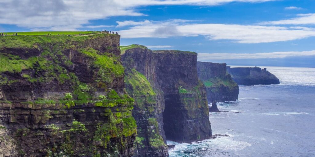 <p>The Cliffs of Moher are a UNESCO Geopark, recognized for their geologic and cultural significance. They’re also one of Ireland’s most instantly recognizable <a href="https://wanderwithalex.com/famous-landmarks-around-the-world/">landmarks</a>. </p><p>These seaside cliffs offer breathtaking sea views along the Atlantic Ocean on the Wild Atlantic Way. Many species of wild seabirds live along the cliffs, including puffins during some parts of the year. Bird watchers will want to bring a pair of binoculars.</p><p>You can see the Cliffs of Moher by parking at the Visitor’s Center, or you can hike along the tops of the cliffs. Stay near the Cliffs of Moher in the small town of Doolin, which boasts a few adorable B&Bs and cozy pubs. </p>