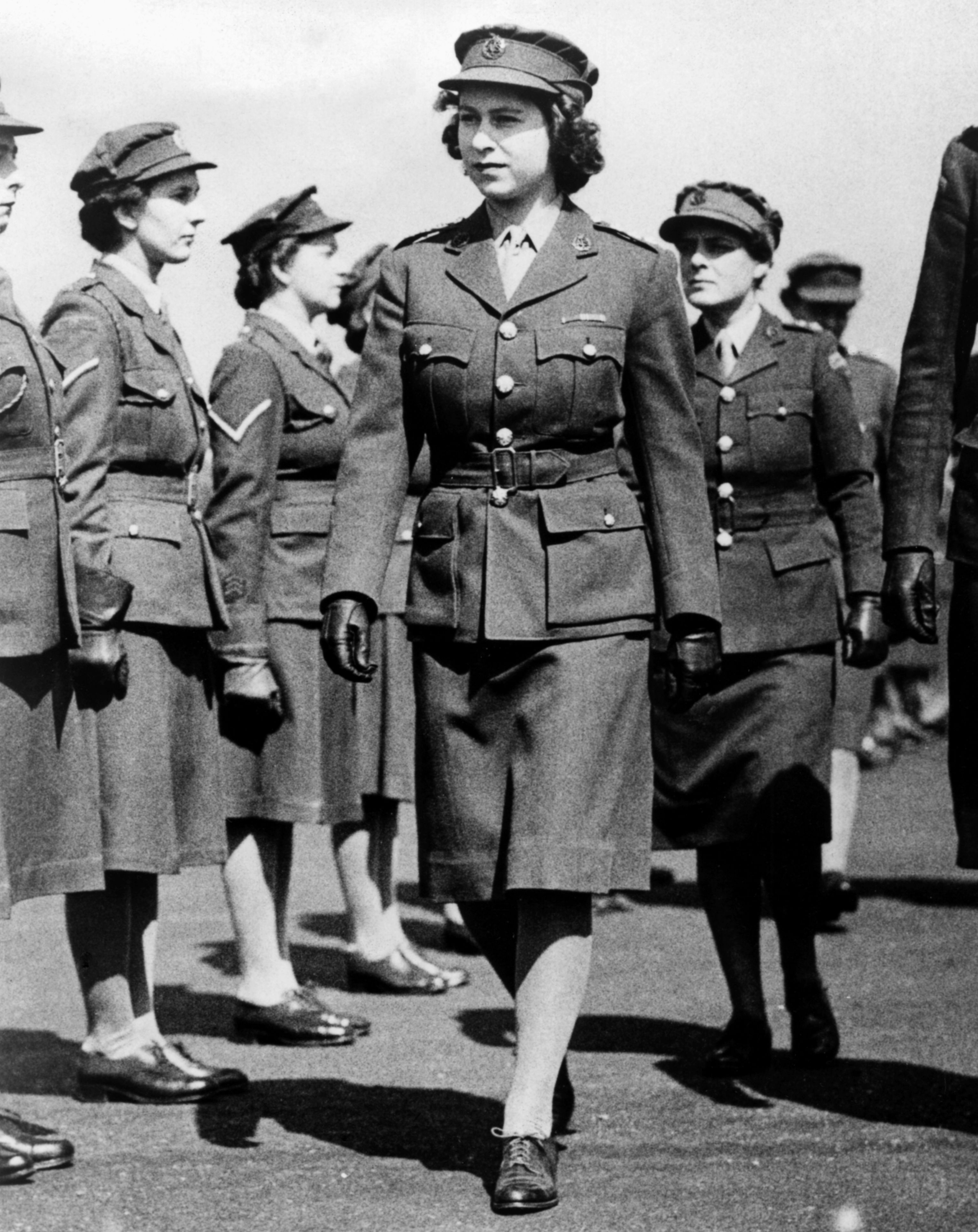 <p>Queen Elizabeth II (then Princess Elizabeth) is seen here during her days as a Junior Commander in the Auxiliary Territorial Service, the women's branch of the British army during World War II. She's pictured inspecting the Motor Transport Training Centre at Camberley in Surrey, England, in 1945 shortly before the war ended. She was the first female member of the royal family to join the armed services as a full-time active member.</p>