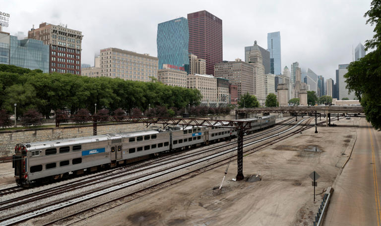 Metra train heads south along the tracks with Michigan Avenue's buildings nearby on June 16, 2023, in Chicago.