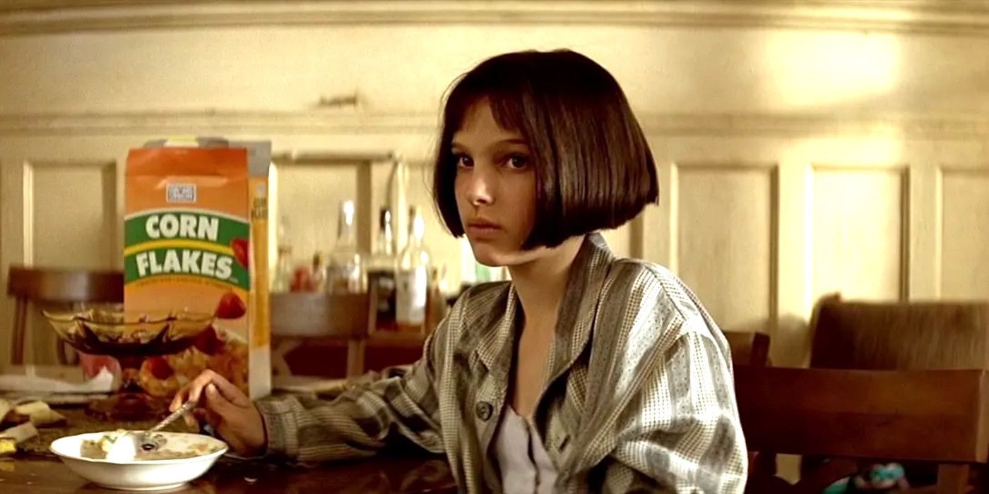 Natalie Portman in Leon the Professional sitting at a table eating Corn Flakes and looking skeptical about something
