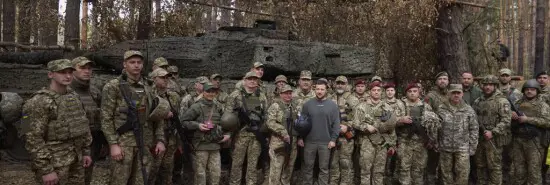 In this photo provided by the Ukrainian Presidential Press Office, Ukrainian President Volodymyr Zelensky, center, poses for a photo with the Ukrainian soldiers in front of a Leopard 2 tank on the front line in the Kharkiv region, Ukraine, Tuesday, Oct. 3, 2023. (AP)