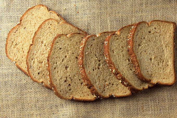 Wholegrain sliced organic bread composed of oats and flax seeds on wooden table. Healthy Diet.Top view