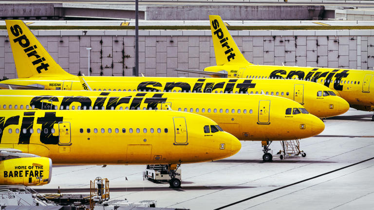 Four Spirit Airlines airplanes are lined up.