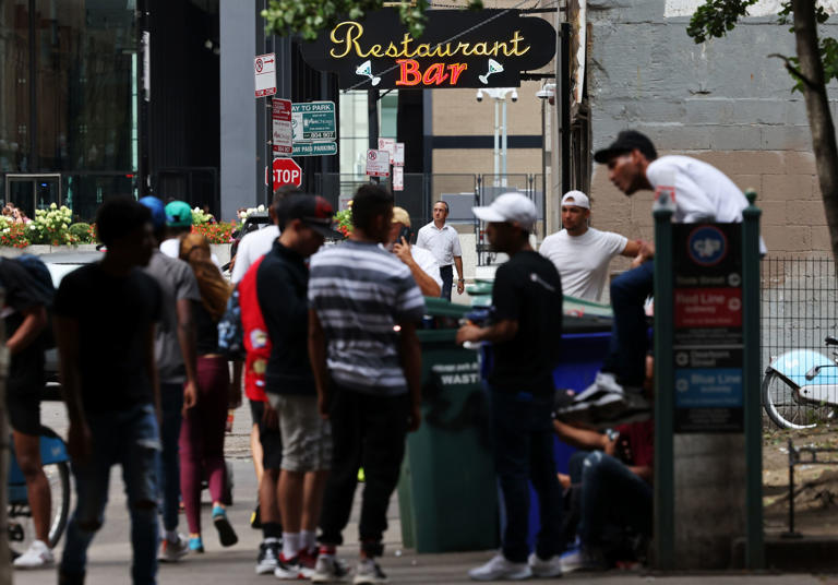 Migrants gather on the edge of Pritzker Park near a restaurant in the 300 block of South Plymouth Court in Chicago on Sept. 5, 2023.