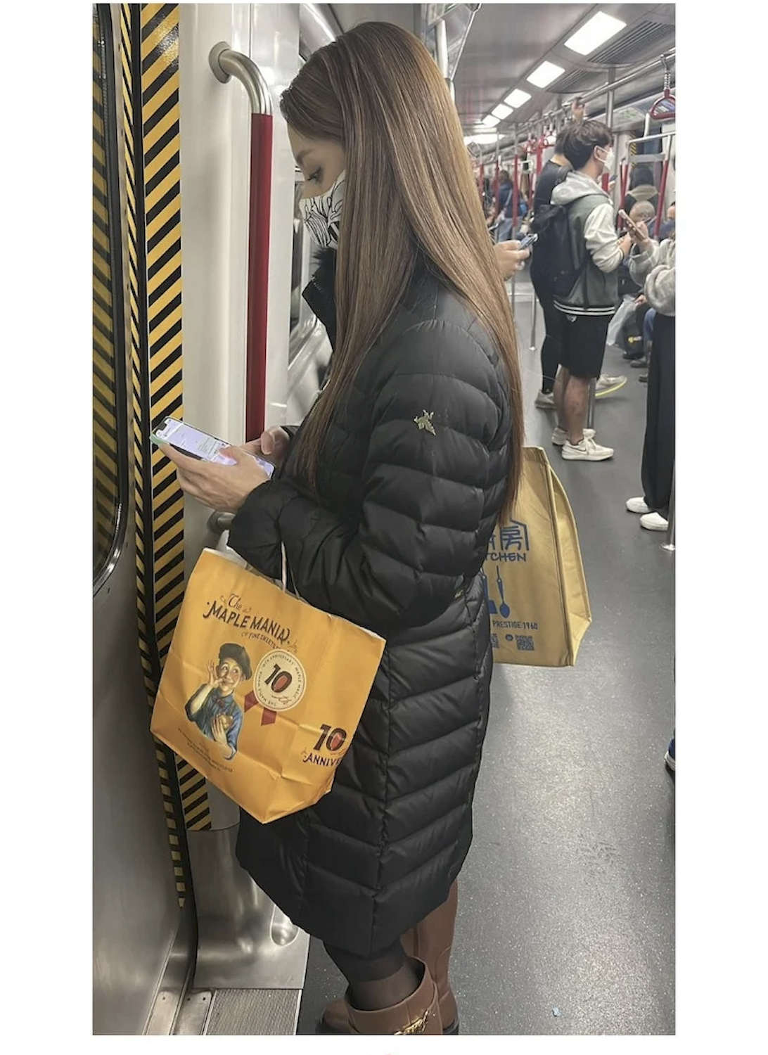 陳凱琳手拿紙袋搭地鐵，低頭滑手機。（翻攝小紅書）