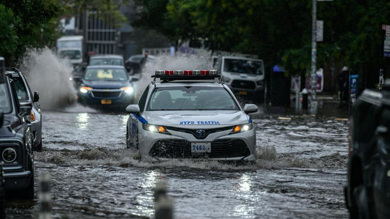 Vehicles make their way through floodwater in Brooklyn, New York on September 29, 2023. AFP via Getty Images