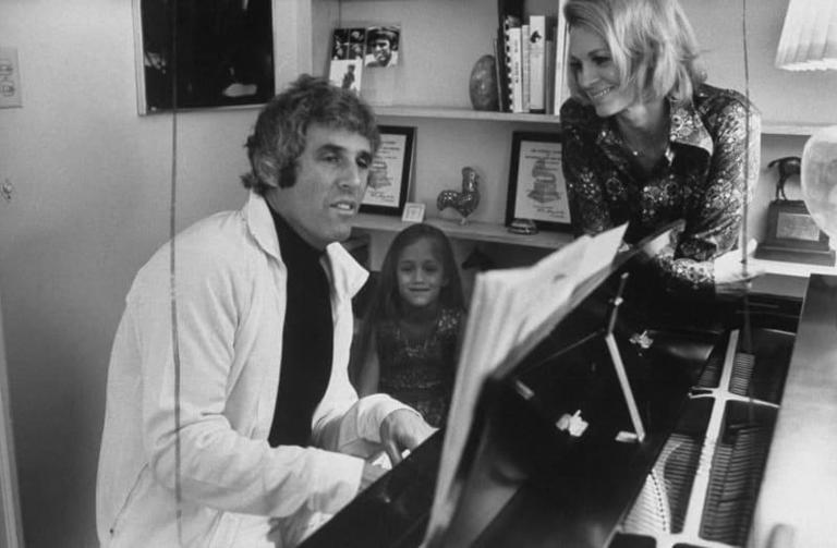Burt Bacharach playing the piano as his Angie Dickinson and daughter watch | Source: Getty Images