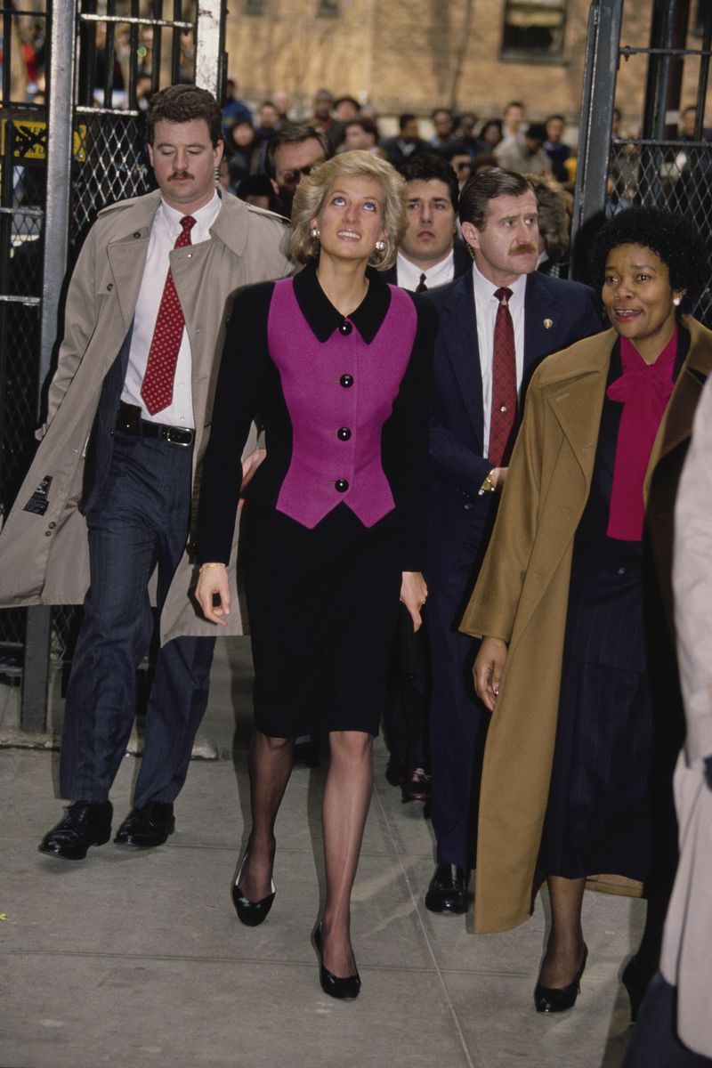 <p>Diana wears a pink and black, colorblocked suit by Catherine Walker. </p>