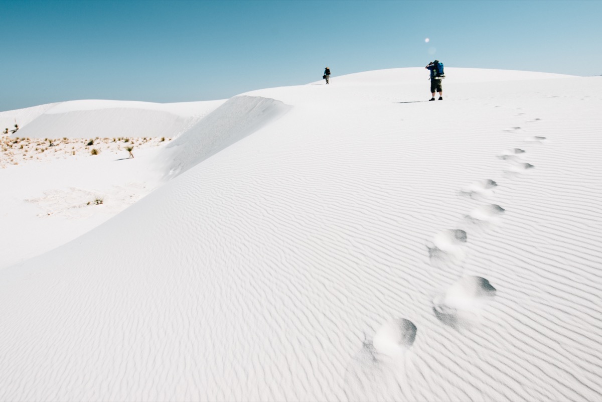 <p>One park that is best seen on foot is <a rel="noopener noreferrer external nofollow" href="https://www.nps.gov/whsa/index.htm">White Sands National Park</a> in New Mexico. According to <strong>Adam Marland</strong>, travel photographer and blogger for <a rel="noopener noreferrer external nofollow" href="https://www.wedreamoftravel.com/white-sands-photography/">We Dream of Travel</a>, if you only drive through, you're doing yourself a disservice.</p><p>"One short road is all you get by vehicle for exploring the ethereal landscape of White Sands National Park; the rest is up to you to explore by foot!" Marland says, adding that you might even want to forgo your sneakers.</p><p>"When I say 'by foot,' I mean that literally," he shares. "Leave your shoes in the car and enjoy any number of trails through the pillowy-soft hills of gypsum that roll ever-onward for miles in each direction."</p><p>Marland also notes that this is a park you have to "see to believe," as the impressive views change between sunrise and sunset.</p><p>"In fact, the 'white sand' for which the park is named is not white, nor sand! It is actually a translucent gypsum that takes on the ambient color of the light," Marland explains. "For most of the day, it appears as white as snow under the bright overhead sunlight. The colors will later transform to match the yellow, orange, and red of the setting sun."<p><strong>RELATED: <a rel="noopener noreferrer external nofollow" href="https://bestlifeonline.com/news-newest-national-parks/">The 7 Newest National Parks You Need to Add to Your Bucket List</a>.</strong></p></p>