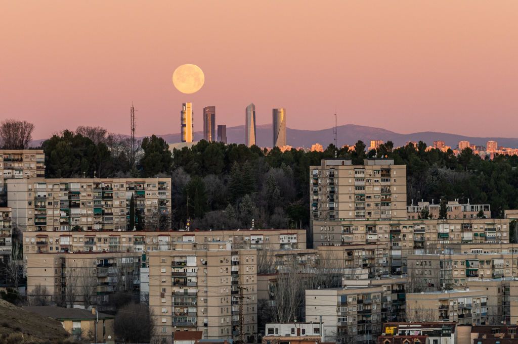 <p>A full moon sets over the Madrid skyline in the middle of winter. The Spanish city is known for its delicious foods, historic buildings, and must-see museums.</p>