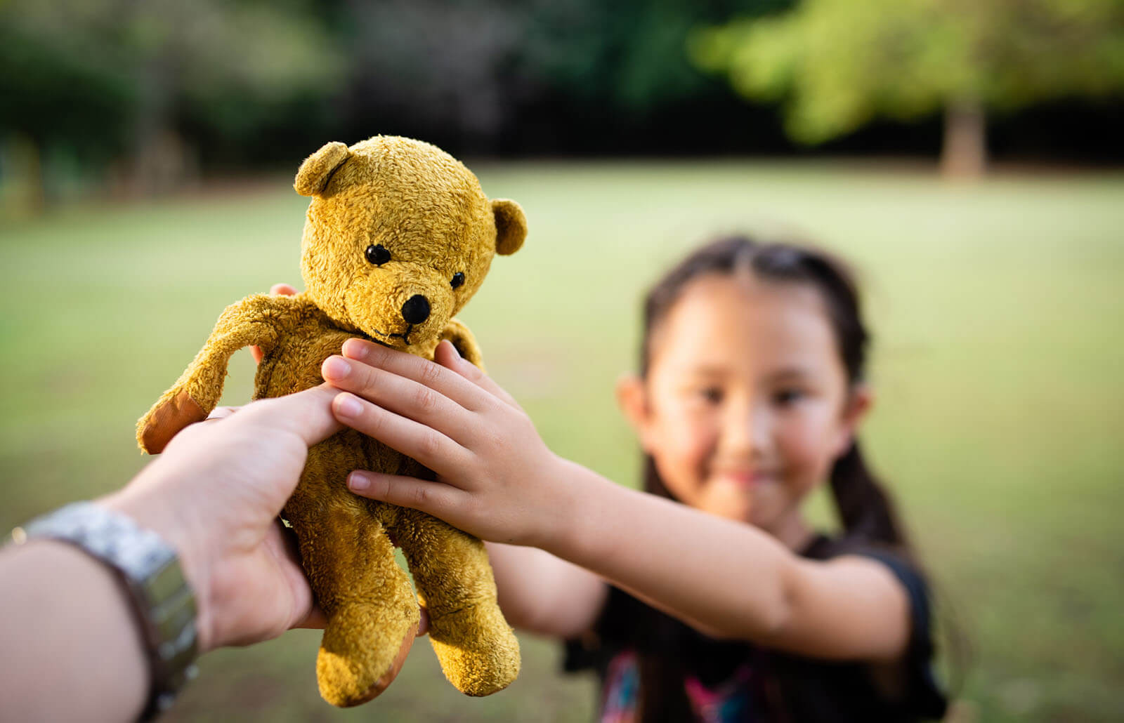 Donate animals. Teddy Bear in child's hand. Child handing his head.