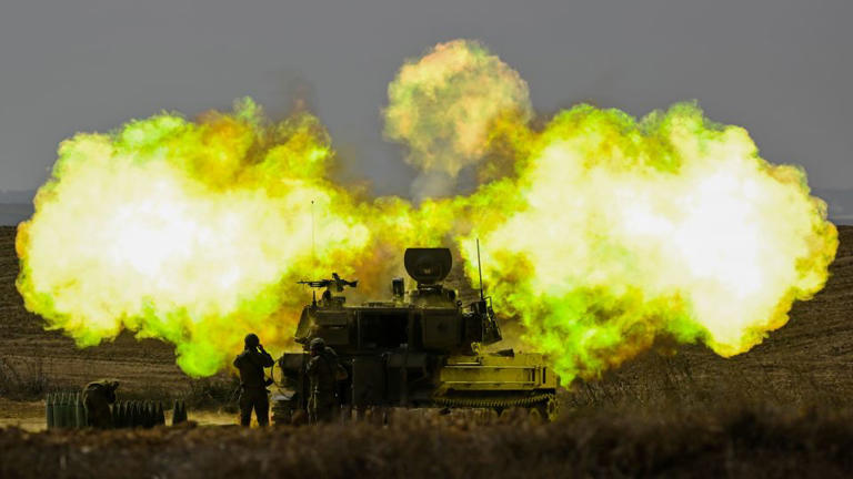 An IDF Artillery solider covers his ears as a shell is fired toward Gaza on October 11, near Netivot, Israel. - Alexi J. Rosenfeld/Getty Images