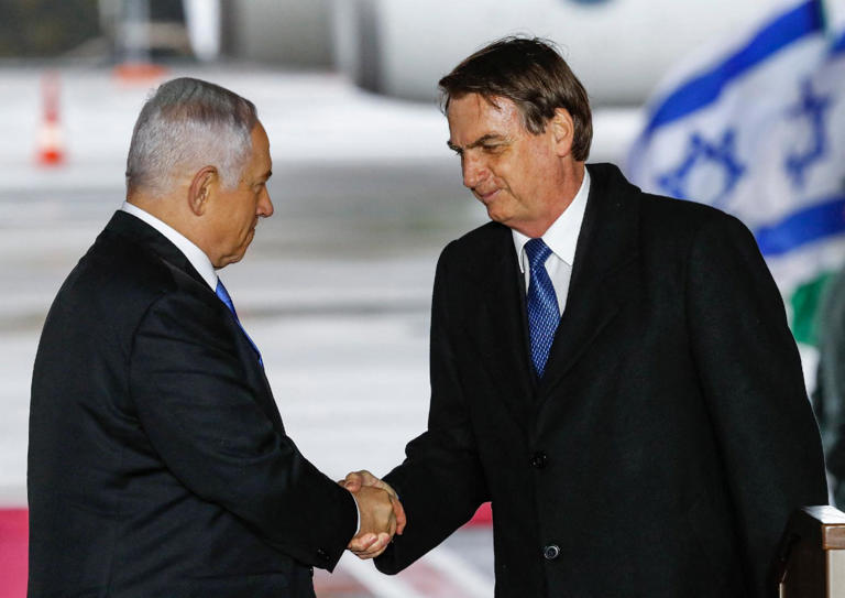 Aperto de mãos entre Benjamin Netanyahu e Jair Bolsonaro na chegada a Israel do ex-presidente brasileiro, em março de 2019 JACK GUEZ AFP