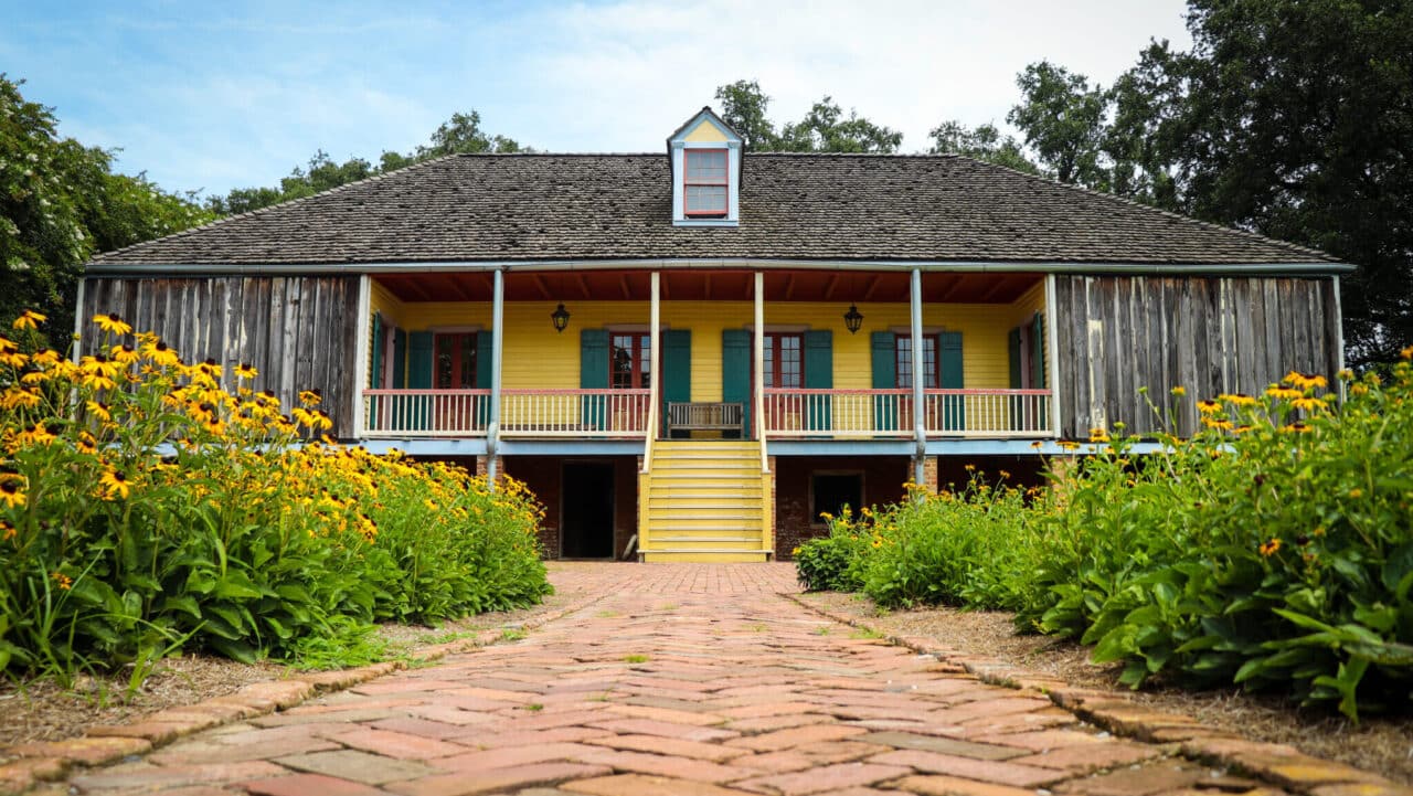 <p>In 1804, a French naval veteran of the American Revolution, Guillaume Duparc, acquired a sugar farming complex on the Mississippi River in Vacherie, <a href="https://wealthofgeeks.com/most-haunted-place-in-louisiana/">Louisiana</a>. Originally called l’Habitation Duparc, it was eventually renamed Laura Plantation. The property today serves as a heritage site for Louisiana’s Creole heritage. </p><p>When Laura Plantation opened to the public in 1994, it became the first historical attraction in Louisiana to include stories of enslaved Africans in its tours. Following extensive research in the United States and France, in February 2017, Laura Plantation introduced a permanent exhibit. <span>“</span>From the Big House to the Quarters: Slavery on Laura Plantation” is dedicated to portraying the authentic history of the enslaved community on this Créole farm. The property is located about an hour’s drive from New Orleans. </p>