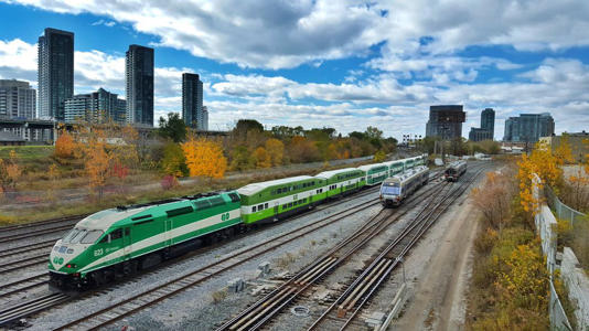 A Go train and airport train come in and out Toronto.