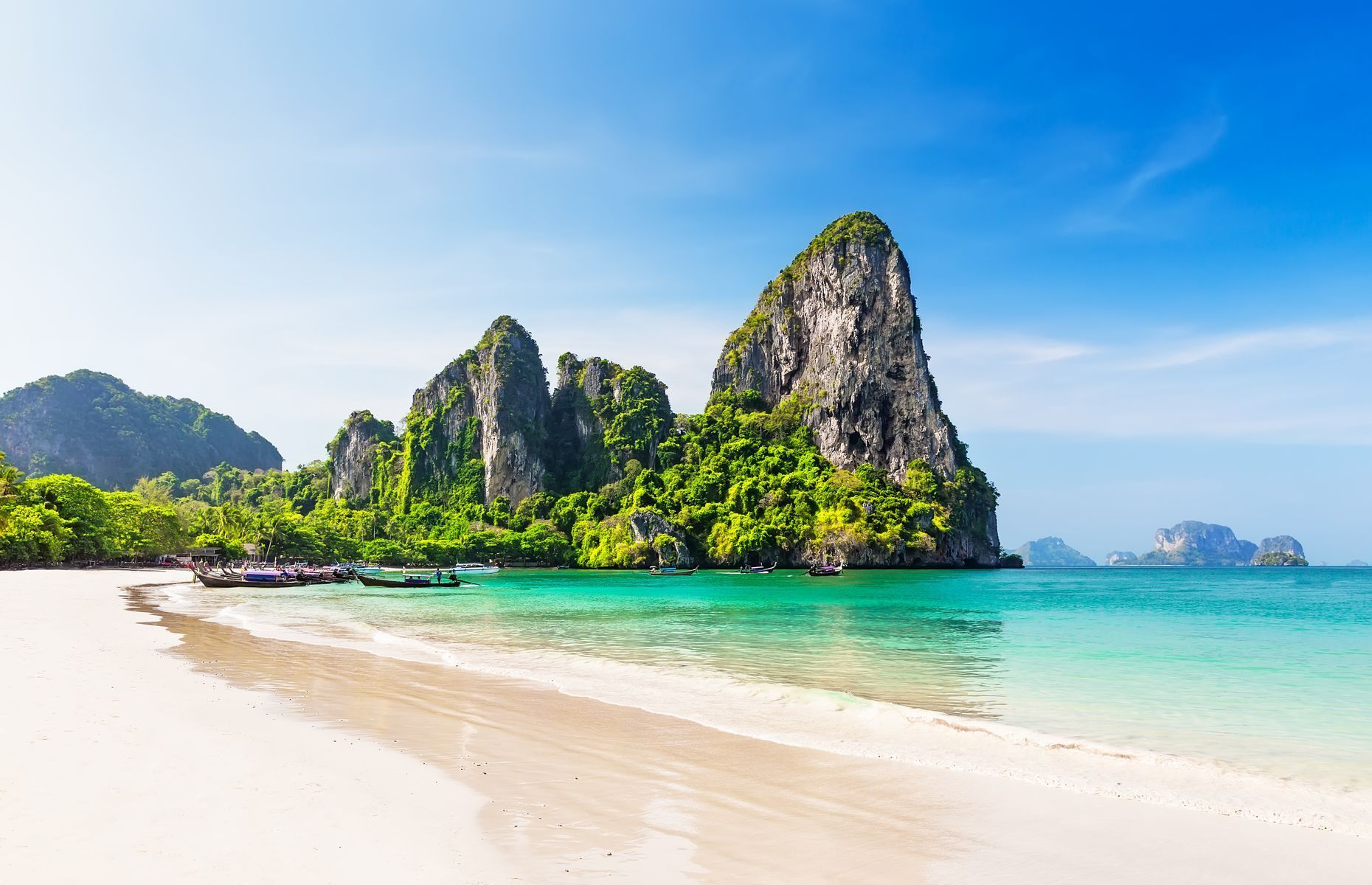Located in southern Thailand’s <a href="https://www.tourismthailand.org/Destinations/Provinces/Krabi/344" rel="noreferrer noopener">Krabi province</a>, <a href="https://www.weseektravel.com/phra-nang-beach/" rel="noreferrer noopener">Railay</a> Beach is a tropical paradise nestled between limestone cliffs on the Andaman Sea. Its fine sand and clear waters offer exceptional opportunities for swimming and kayaking. Accessible by boat, the site includes Phra Nang, just off Railay Beach, and other explorable caves with imposing stalactites.