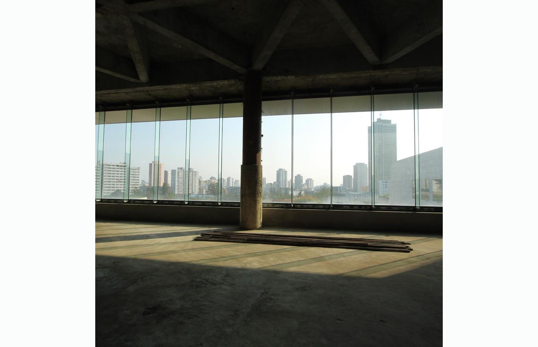 <p>Some parts of the building, like this interior cityscape view through floor-to-ceiling windows, wouldn't be out of place in any office block or undeveloped apartment block in any of the world's major cities.</p>
