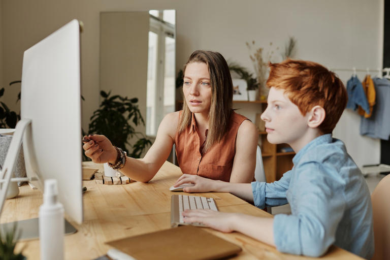 woman helping child with homework