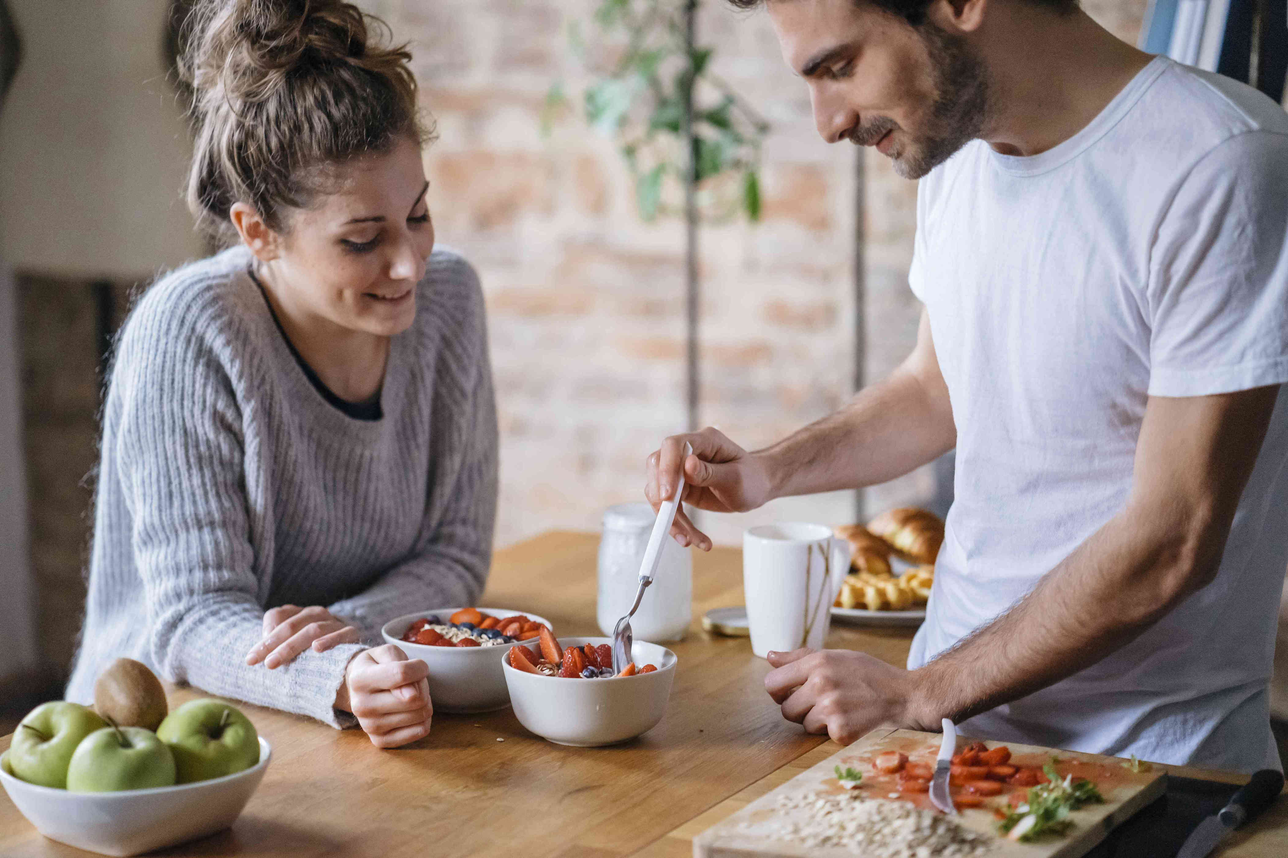 Eat loads. Семейный завтрак фрукты. Здоровое питание для мужчин. Пара завтракает на кухне. Мужчина и женщина завтракают.