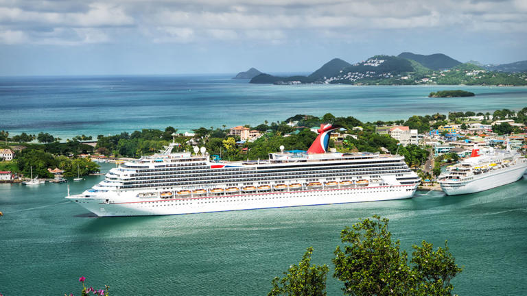 A Carnival Cruise Line ship docked in port. Lead JS