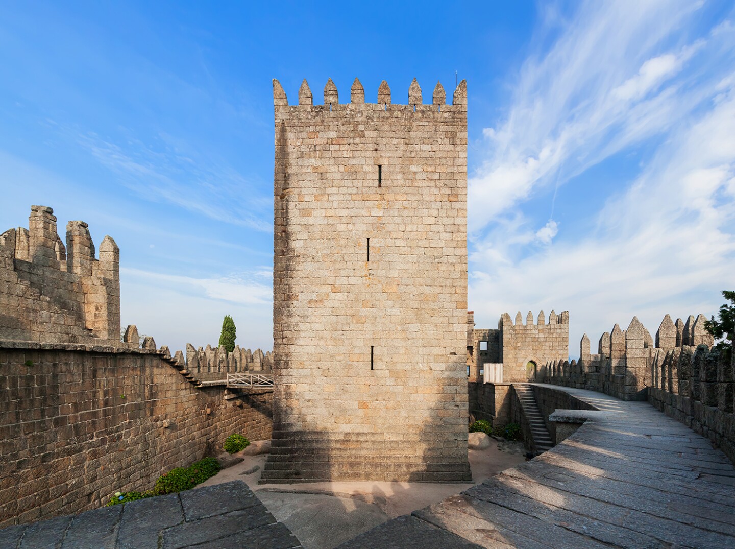 <h2>8. Castle of Guimarães</h2> <p><i>Guimarães, Portugal</i></p> <p> If you want to see where Portugal began, head to the <a class="Link" href="https://afonsina.guimaraes.pt/paco/?page_id=884&lang=en" rel="noopener">Castle of Guimarães</a>, the birthplace of the nation’s first king, Afonso Henriques, in 1109. It’s perched on a hill above the northern Portuguese city of Guimarães, the country’s first capital. Over hundreds of years, the blocky crenellated towers of the mighty Romanesque fortress defended the nation against Moorish, Norse, and Spanish invaders. In the 16th century, it fell into disuse and was used primarily as a prison; it was classified as a national monument in 1881 and later restored. There’s not much left inside the walls, but the nominal entrance fee gets you access to the ramparts and the central keep’s permanent exhibition about the history of Guimarães and its castle.</p> <h3>How to visit Castle of Guimarães</h3> <p>It’s about a 10-minute stroll up to the castle from Guimarães, which can be reached in about 1.5 hours by train from Porto. There’s also a car park directly behind the castle.</p>