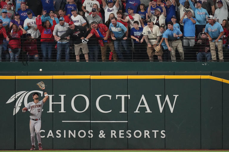 Arizona Diamondbacks left fielder Lourdes Gurriel Jr. (12) catches a fly ball hit by Texas Rangers' Nathaniel Lowe during the fifth inning in Game 2 of the World Series, Saturday, Oct. 28, 2023, in Arlington.