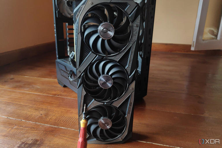 A screwdriver resting on an RTX 3080 Ti, with an MSI MAG Forge 110R in the background.