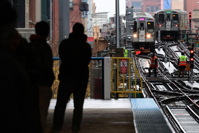 CTA commuters watch trains approach from the Clark and Lake station in Chicago's Loop on Nov. 8, 2023.