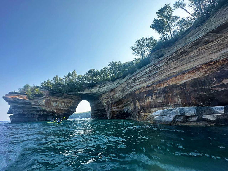 Pictured Rocks National Lakeshore is a natural wonderland on the southern Lake Superior in Michigan’s Upper Peninsula. It’s known for spectacular, colorful sandstone cliffs that span 15 miles of freshwater shoreline with unique rock formations, sandy beaches and verdant forests. If you like a natural environment and a place to truly escape it all, this place is worth visiting. The park’s name comes from the sandstone cliffs that border the edge of Lake Superior and seem to rise from its depths majestically. The Pictured Rocks formed from wind and waves over a long period and the mineral-rich surrounding forest groundwater seeping through the cliffs’ cracks created a palette of colors ranging from fiery oranges to cool blue-green. Today’s landscape features sea caves, arches, blowholes, turrets, stone spires, and other features rising 50-200 feet above the water. The best way to see them is from the water, but that’s not the only way. I’ve visited a few times and seeing the rocks from both land and shore are different and worthwhile experiences. Popular Pictured Rocks Sandstone Formations Various colorful rock formations span the 15 miles of seashore that make up the Pictured Rocks. While even the tall, flat sandstone slabs that […]