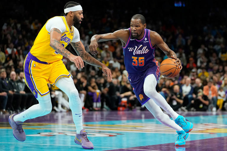 Phoenix Suns forward Kevin Durant (35) drives on Los Angeles Lakers forward Anthony Davis during the first half of an NBA basketball game, Friday, Nov. 10, 2023, in Phoenix. (AP Photo/Matt York)