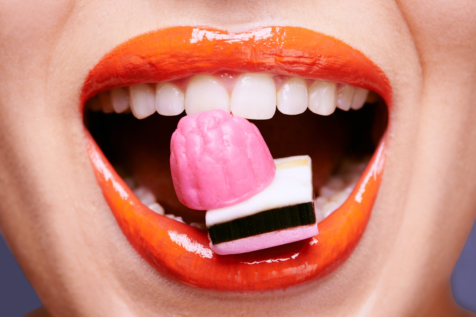 Губы с конфетой. Фото губ с леденцом. Фото губ как видят сладости. Картинки человек с зубами ест конфету.