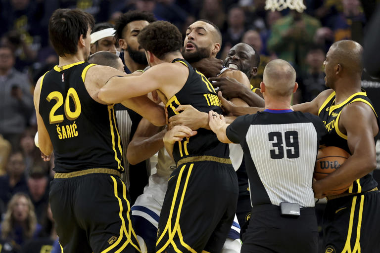 Golden State Warriors' Klay Thompson, front, and Draymond Green, back, get into an altercation with Minnesota Timberwolves center Rudy Gobert. (AP Photo/Jed Jacobsohn)