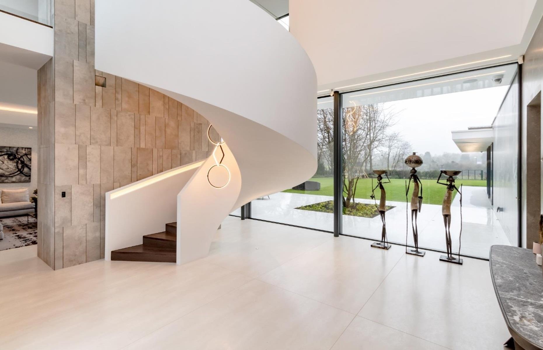 <p>The front door opens into a gorgeous entrance hall, complete with a bespoke spiral staircase and Flos chandeliers. The space flows through to a formal living room, Siematic kitchen, study, luxurious cinema room, home gym and indoor swimming pool – complete with a jacuzzi.</p>