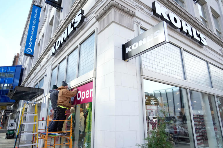 Works is done to adhere the open sign to the window at the new Kohl's store at 630 N. Vel R. Phillips Ave. in downtown Milwaukee on Thursday, Nov. 2, 2023. The 35,000 square foot store opens Friday, Nov. 3 just in time for the holiday season.