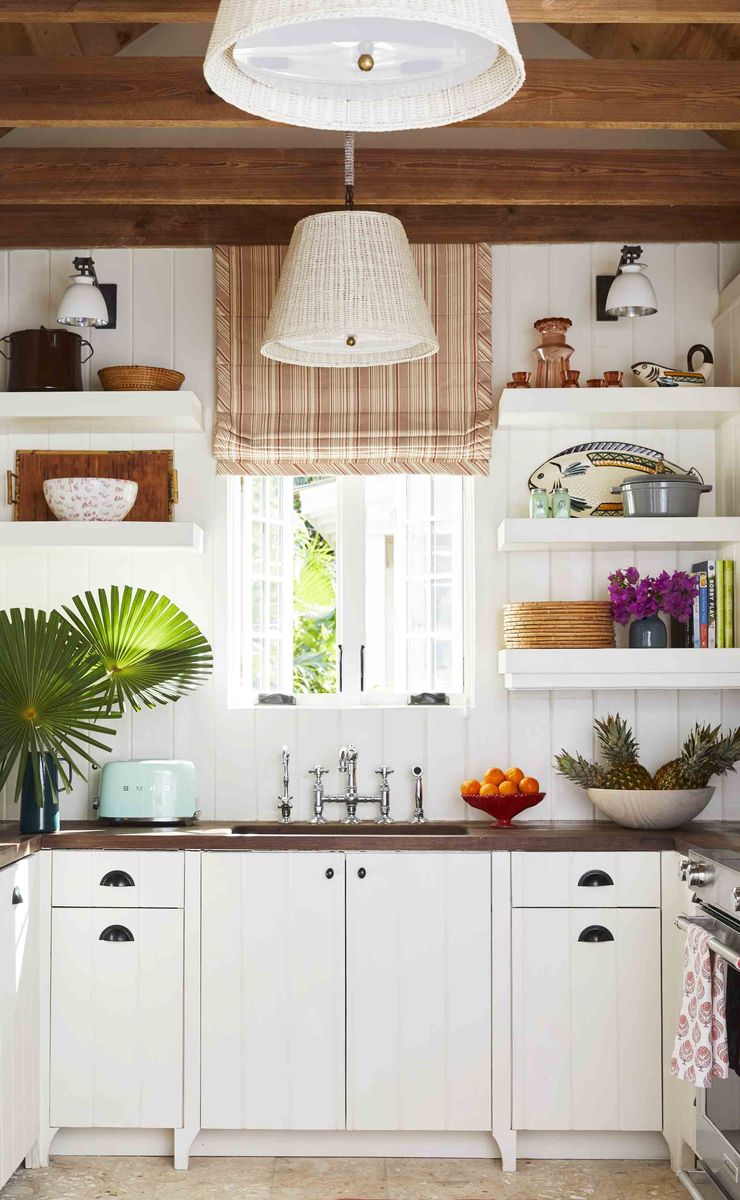 <p>In the kitchen of <a href="https://www.veranda.com/decorating-ideas/house-tours/a32721431/matthew-carter-harbour-island-cottage/">designer Matthew Carter's Bahamas hidewaway</a>, mahogany countertops, Abaco pine beams, and vintage wicker pendant shades ground the room in organic island simplicity. Sink fixtures, <a href="https://www.rohlhome.com/">Rohl</a>.</p>
