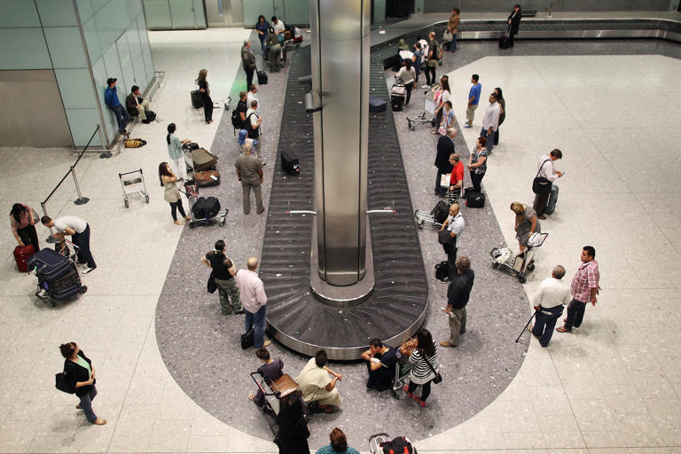 Passengers wait in the baggage hall at terminal five at Heathrow airport on August 27, 2010 in London, England