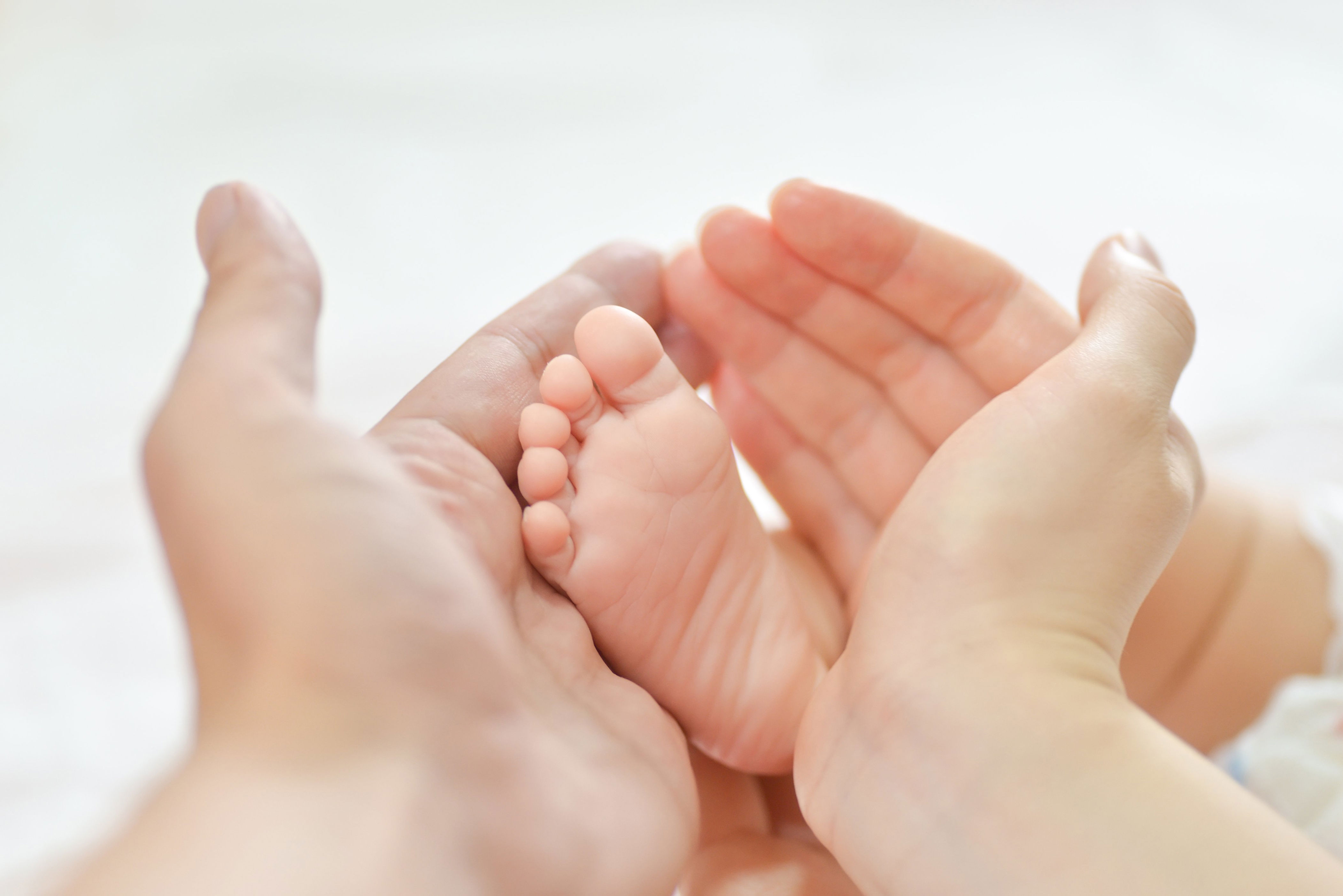 Руки и ноги коликами. Ножки младенца. Ребенок на руках. Детская ножка в руках. Маленькие ножки.