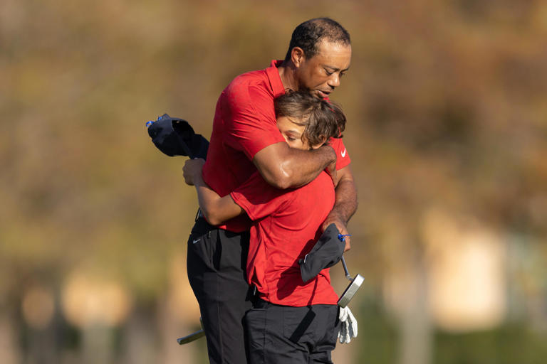 Dec 19, 2021; Orlando, Florida, USA; Tiger Woods and son Charlie Woods hug after the final round of the PNC Championship golf tournament at Grande Lakes Orlando Course. Mandatory Credit: Jeremy Reper-USA TODAY Sports