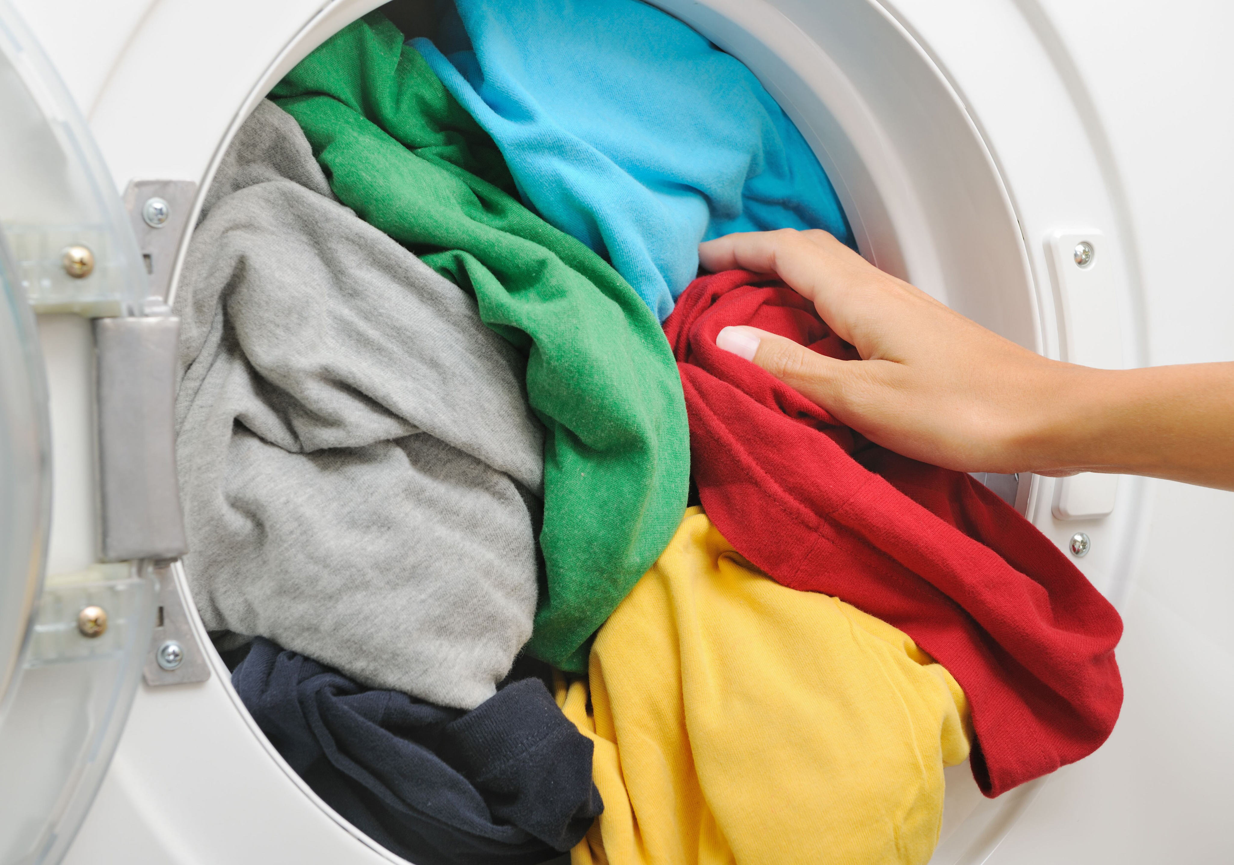 Можно ли стирать плащ. Одежда в стиральной машине. Стирка одежды. Стиральная машинка с вещами. Цветные вещи в стиральной машине.