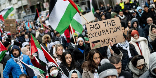 Menschen nehmen mit Schildern mit der Aufschrift "End the occupation now" an einer Demonstration für Palästina in Berlin-Mitte teil. dpa