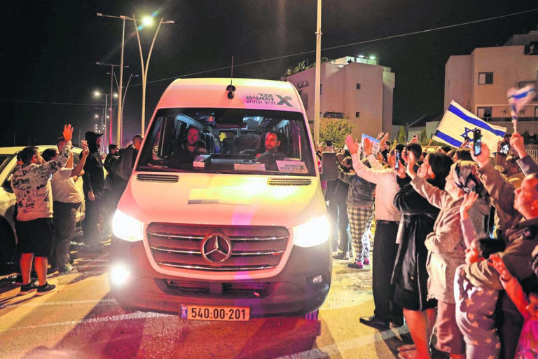 La gente aplaude mientras un vehículo que transporta rehenes liberados por Hamas se dirige hacia una base militar en Ofakim, en el sur de Israel. Foto: AFP