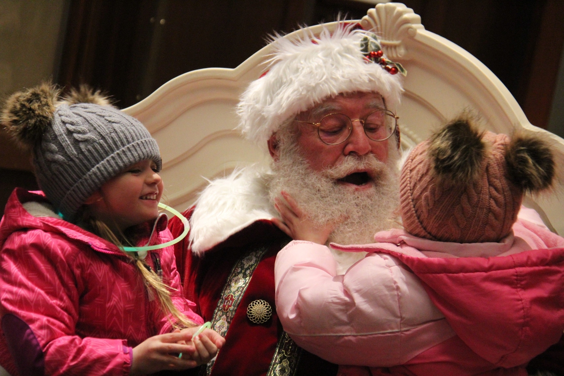 Karli, left, and Kali Ferguson visit with Santa Claus at the Hotel Pattee on Friday, Nov. 24, 2023, after Perry's Lighted Holiday Parade.