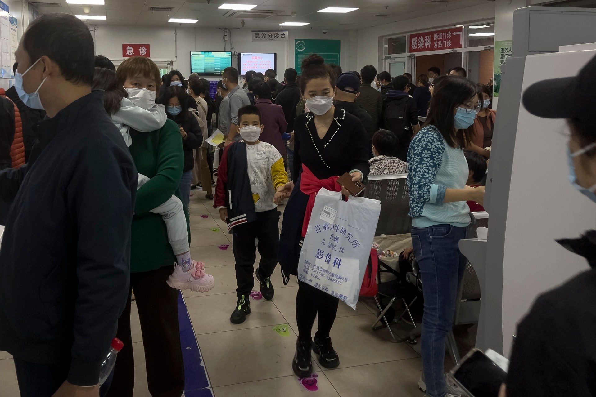 scarily familiar scenes in china after 'mask-wearing' crowds pile into hospitals
