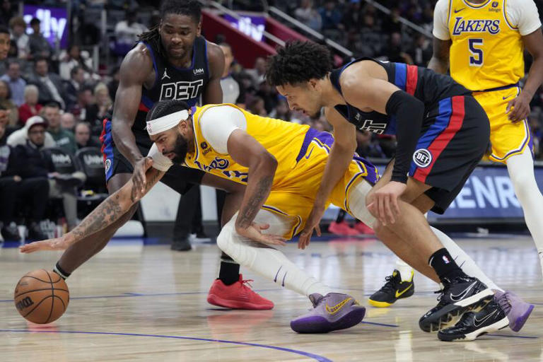 Pistons guard Cade Cunningham (2) and Lakers forward Anthony Davis (3) chase a loose ball during a game Wednesday in Detroit. ((Carlos Osorio / Associated Press))