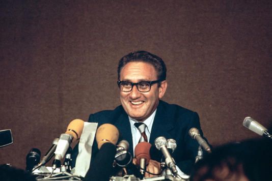 Henry Kissinger laughs during a press conference after the final communique on the Vietnam Peace Accords, signed by Kissinger and Le Duc Tho