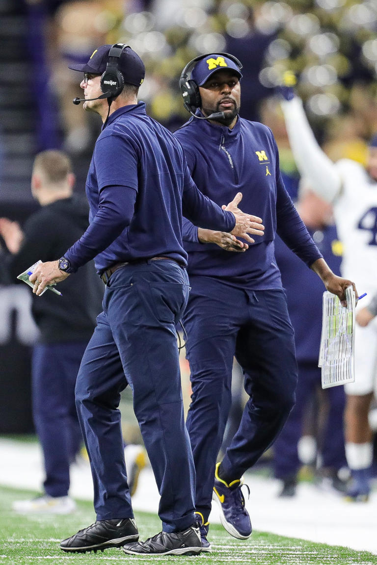 Michigan coach Jim Harbaugh high-fives offensive coordinator Sherrone Moore after a play during the second half of U-M's 26-0 win over Iowa in the Big Ten championship game in Indianapolis on Saturday, Dec. 2, 2023.
