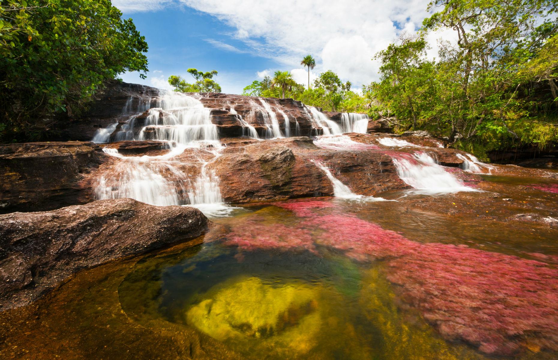 <p>When it comes to beautiful natural phenomena, central Colombia’s Cano Cristales takes some beating. During certain times of the year, the 62-mile-long 'liquid rainbow' river changes color thanks to an aquatic plant called macarenia clavigera, transforming with vibrant shades of yellow, pink, red, green, blue, and orange. Until relatively recently it was too dangerous to visit due to guerrilla activity, but the area is now controlled by the Colombian military and tourists once again have access.</p>